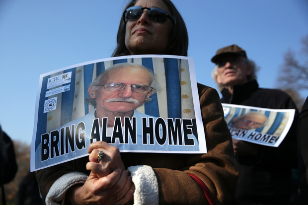 This 2013 photo shows supporters holding signs to call on the U.S. to bring home U.S. citizen Alan Gross, who was held in a prison in Cuba.  Gross was released Dec. 17. 