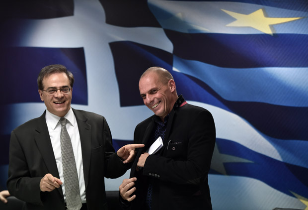 Greece's outgoing Finance minister Gikas Hardouvelis (L) jokes with the new Finance minister Yanis Varoufakis after a ministry hand-over ceremony Jan. 28 in Athens.