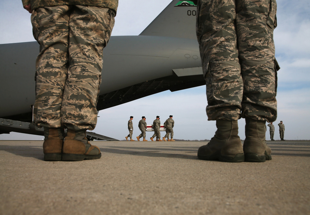 A US Army carry team moves a transfer case   during a dignified transfer at Dover Air Force Base, on December 16, 2014 in Dover, Delaware.