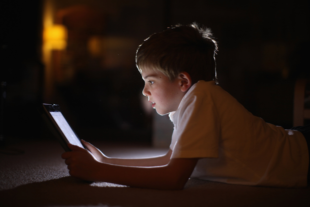 In this photograph illustration a 10-year-old boy uses an Apple iPad.