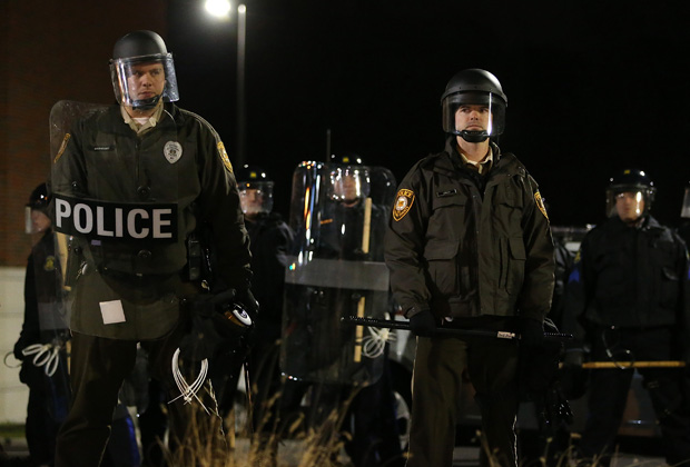 This file photo from November 2014 shows St. Louis County police officers in riot gear, standing guard in front of the Ferguson police department after a grand jury decided to not indict Ferguson police Officer Darren Wilson in the shooting of Michael Brown.