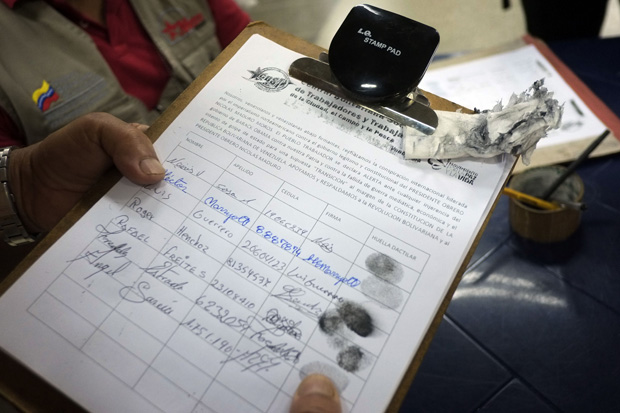 People sign documents March 9 to show their support for the Venezuelan government after the United States imposed sanctions on Venezuelan officials over rights abuses.