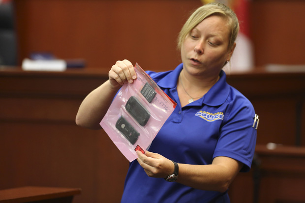 A crime scene technician for the Sanford Police Department shows the jury a cell phone that was collected as evidence for George Zimmerman's 2013 trial in Sanford, Florida. 