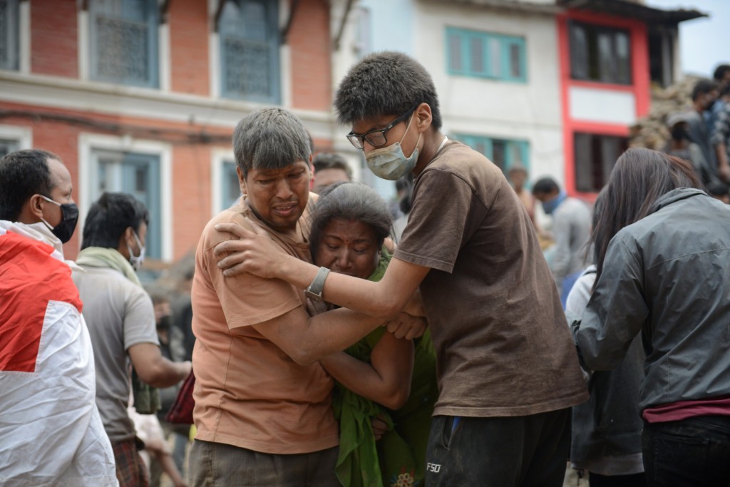 Earthquake victims are helped by a rescuer in Kathmandu's Durbar Square after an earthquake on April 25, 2015. 