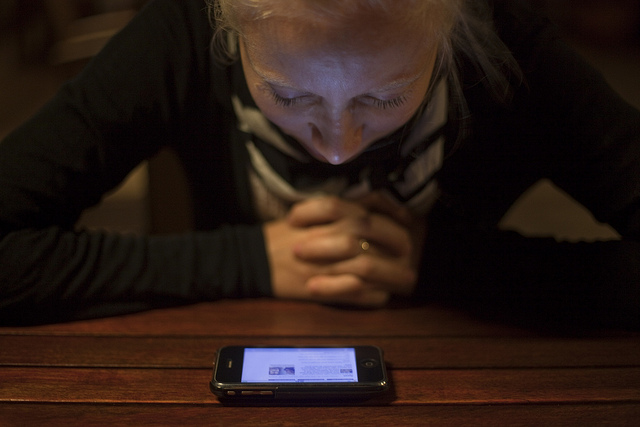 A girl reads the news on a smartphone. 