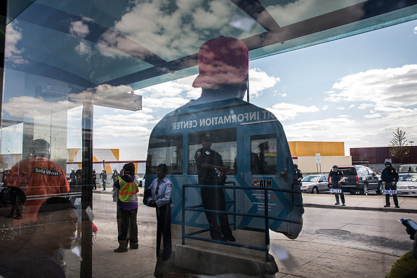 People wait for the bus at the Mondawmin Station while police secure Mondawmin Mall on April 29, 2015 in Baltimore, Maryland. 