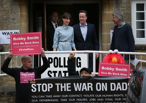 Prime Minister David Cameron and his wife Samantha look at demonstrators May 6 as they leave a polling station for the general election in Spelsbury, England.  