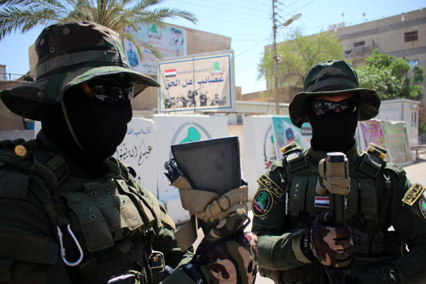 Iraqi fighters of the Shiite militia The League of the Righteous stand guard outside their headquarters  May 18 2015 in Basra, as Shiite militias converged on Ramadi in a bid to recapture it from ISIS.