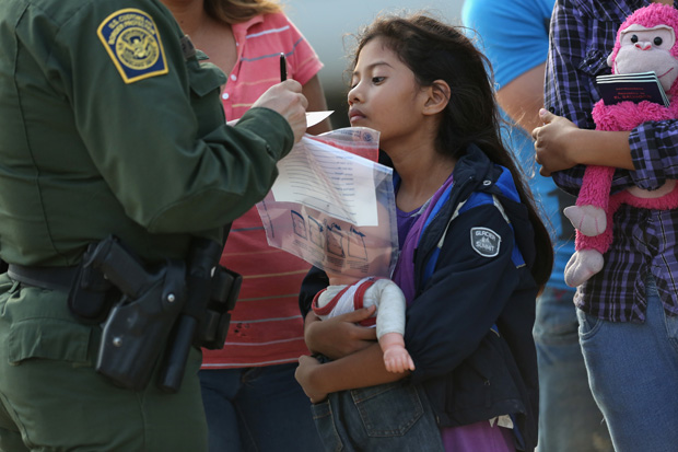 Salvadorian immigrant Stefany Marjorie, 8, watches as a U.S. Border Patrol agent records family information on July 24, 2014 in Mission, Texas. 
