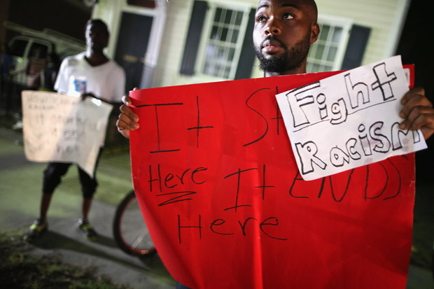  Curtis Clayton holds a sign protesting racism in the wake of the shooting at the historic Emanuel African Methodist Episcopal Church  in Charleston, South Carolina. 