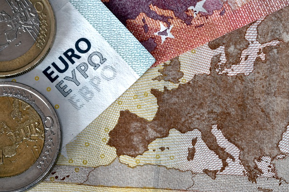 A picture taken July 11 in Athens shows euro coins and banknotes with the map of Europe.