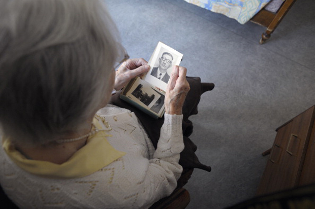 A woman, suffering from Alzheimer's disease looks at an old picture in a retirement house in Angervilliers, eastern France.  