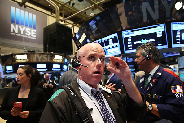 Traders wait for trading to resume July 8 on the floor of the New York Stock Exchange (NYSE) in New York City after trading was halted due to a technical glitch. 