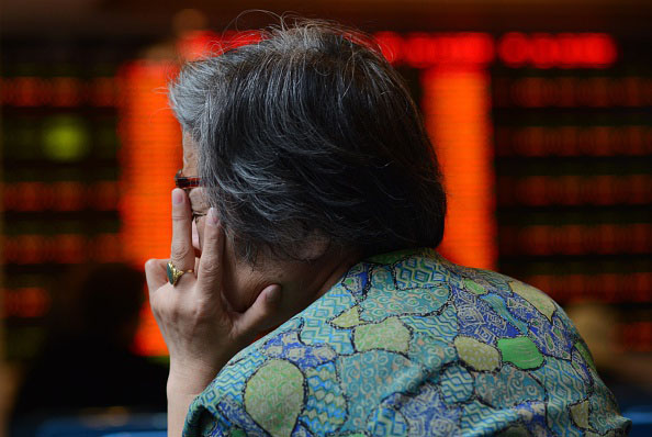 A stock investor reacts July 6 in front of a screen showing stock market movements in a brokerage house in Shanghai. 