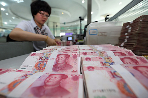 A teller counts yuan banknotes Aug. 11 in a bank in Lianyungang, east China's Jiangsu province .China's central bank devalued its yuan currency by nearly 2 percent against the U.S. dollar. 