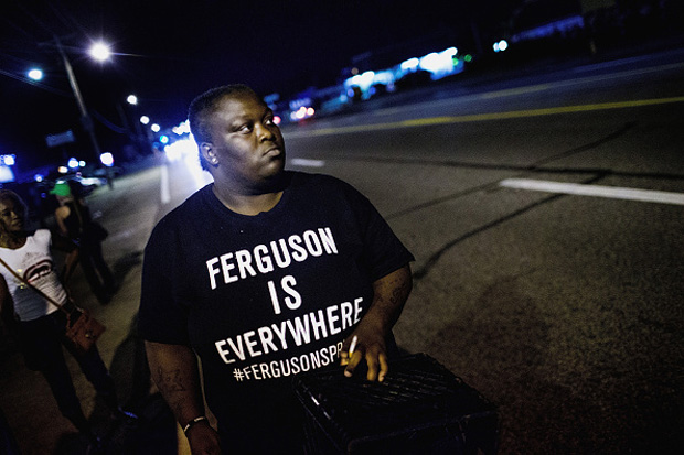 Demonstrators, marking the one-year anniversary of the shooting of Michael Brown, protest Aug. 11 along West Florrisant Street in Ferguson, Missouri.  
