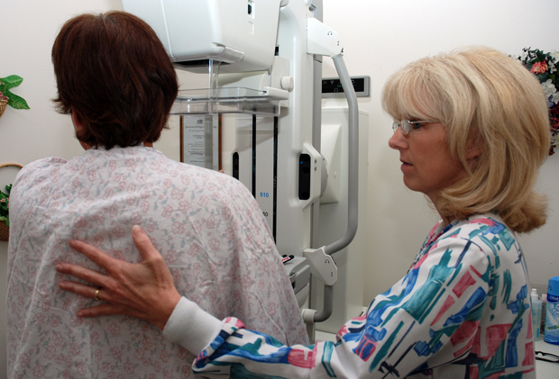 Lead Mammography Technologist Carmen Waters assists a patient preparing for a mammogram.  