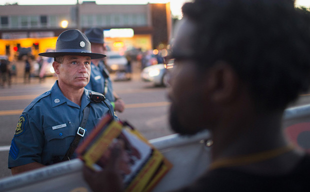 A demonstrator, marking the one-year anniversary of the shooting of Michael Brown, confronts police Aug. 10 during a protest along West Florrisant Street in Ferguson, Missouri. 