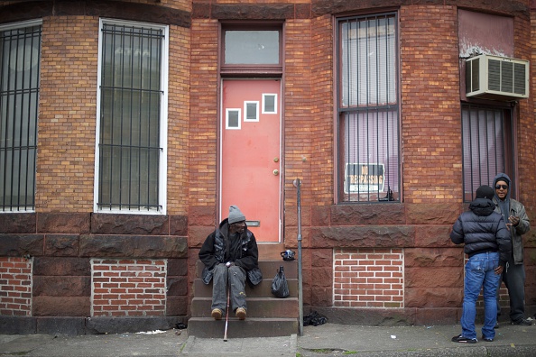 A man sits on fronts steps in a neighborhood near the Western District Police Station after the  death of Freddie Gray in Baltimore, Maryland. 