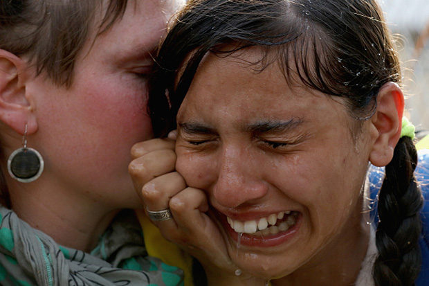 A migrant girl is overcome by pepper spray and tear gas after Hungarian police repelled a Sept. 16 attempt by migrants to break the border post gate and pull down the razor wire fence in Horgos, Serbia. 