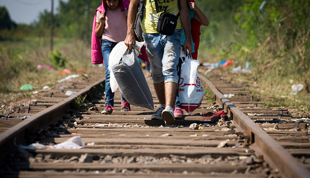Migrants walk along a railway line Aug. 30 after they have crossed the border from Serbia into Hungary. 
