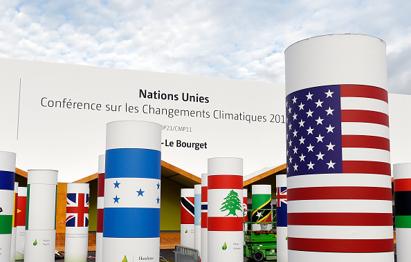 Pillars with the names and national flags of countries attending the UN climate conference known as COP 21 decorate the outside of the venue hall in Le Bourget, north of Paris.