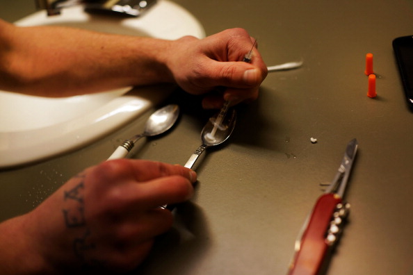 A heroin addict in Vermont prepares to inject the drug.