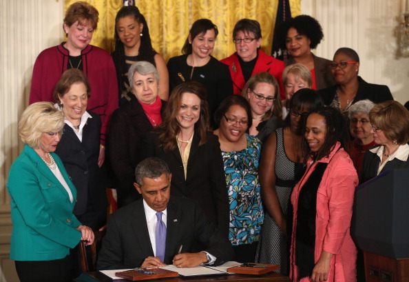 President Barack Obama signs an executive order in April 2014 intended to force federal contractors to address unequal pay. He presented new rules last week that would require companies with 100 or more employees to include salary information on a form they already submit that reports employees’ sex, age and job groups. 