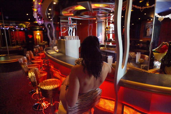 A sex worker poses at the bar of Berlin's Artemis brothel May 4, 2006. Artemis, the largest brothel in Berlin, boasts 4 stories, 70 rooms, 3 saunas, 2 small movie theaters, a pool and a fitness center.