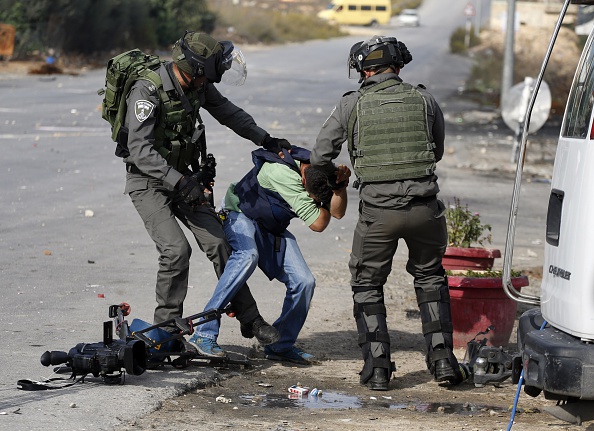 Israeli border guards aggress a journalist during clashes between Palestinian demonstrators and Israeli security forces at the entrance of the Palestinian town of Al-Bireh on the outskirts of Ramallah in the Israeli-occupied West Bank, on October 30, 2015.