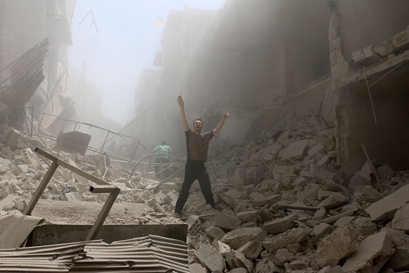 A man gestures amid the rubble of destroyed buildings following a reported air strike on the rebel-held neighbourhood of al-Kalasa in the northern Syrian city of Aleppo, on April 28.