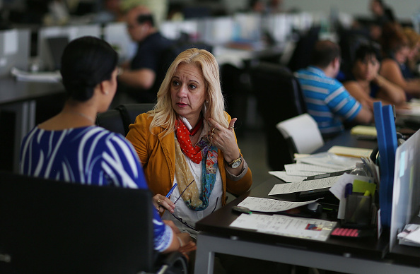 Maria Elena Santa Coloma,(R) an insurance advisor with UniVista Insurance company, helps Shessy Gonzalez sign up for a health plan under the Affordable Care Act, also known as Obamacare, on December 15, 2015 in Miami, Florida.