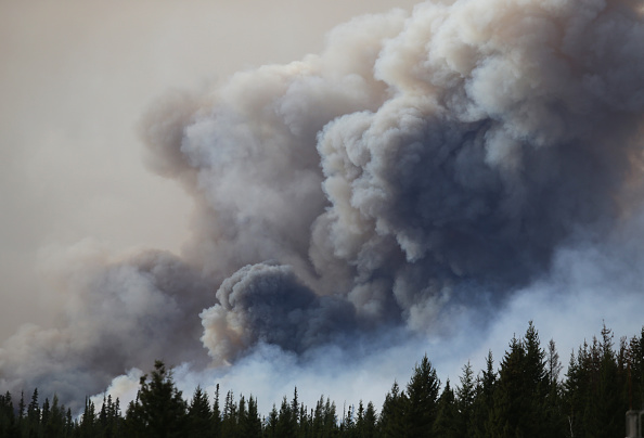 Flames rise off Highway 63 on May 7 outside Fort McMurray, where raging forest fires forced more than 88,000 from their homes.