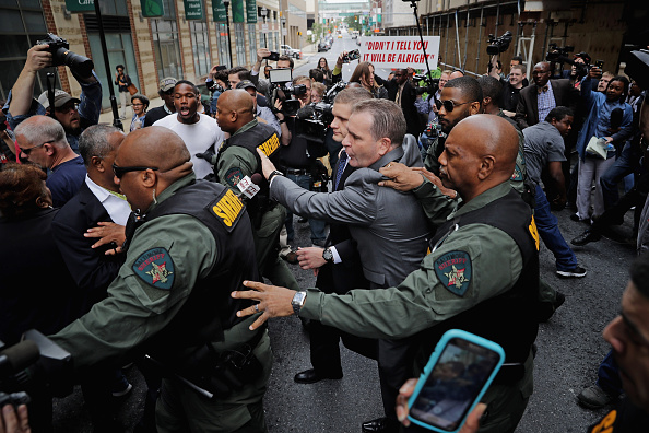 Baltimore City Sheriff's Deputies surround and protect Baltimore Police Officer Edward Nero's family members as demonstrators and members of the news media crowd around outside the Mitchell Courthouse-West after Nero was found not guilty on all charges against him related to the arrest and death of Freddie Gray May 23 in Baltimore, Maryland. 