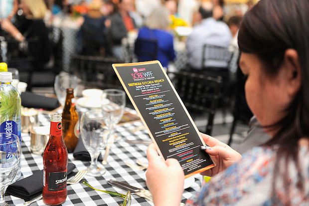 A guest views a menu at the Southern Kitchen Brunch Hosted By Trisha Yearwood — part of The New York Times Cooking Series — at Loews Miami Beach Hotel on February 28, 2016 in Miami Beach, Florida. 