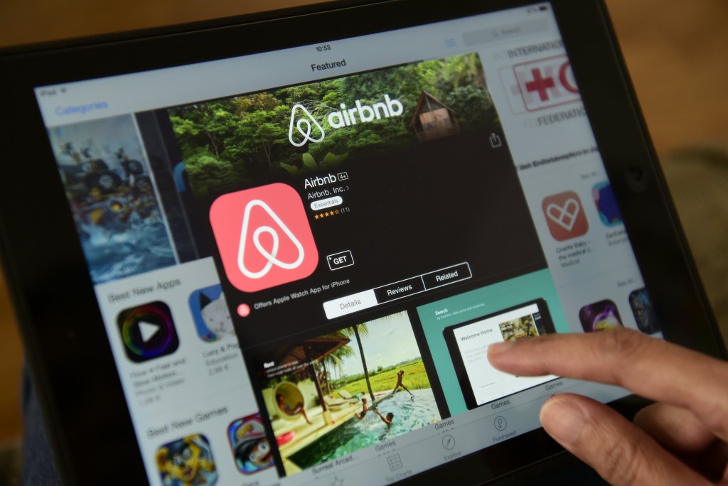 A woman browses the site of US home sharing giant Airbnb on a tablet in Berlin on April 28, 2016.