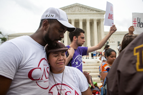 Rosario Reyes, an undocumented mother from El Salvador, reacts to news on a Supreme Court decision blocking Obama's immigration plan, which would have protected millions of immigrants from deportation, in front of the U.S. Supreme Court, on June 23 in Washington, DC. The court was divided 4-4, leaving in place an appeals court ruling blocking the plan.