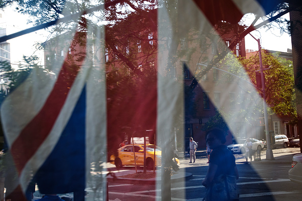 A British flag hangs in the window of Myers of Keswick, a British grocery store, June 24 in New York City.