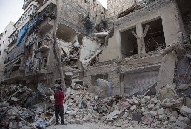 A Syrian man stands next to the debris outside a building hit by overnight shelling in Aleppo's rebel-held Qasr al-Bustan neighbourhood on June 9, 2016. 