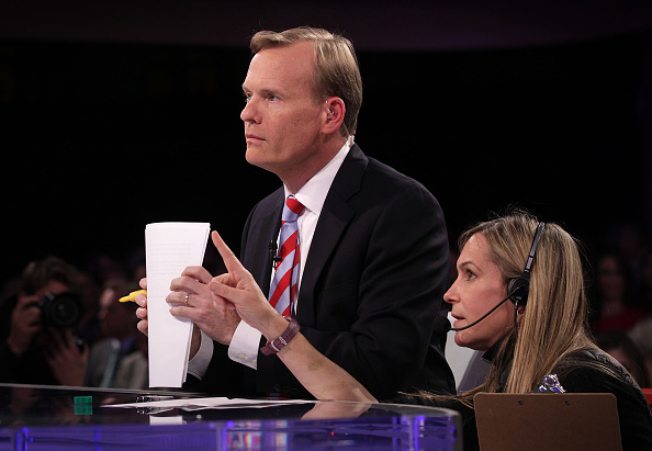 "Face the Nation" anchor John Dickerson (L) listens to a crewmember prior to a presidential debate sponsored by CBS at Drake University on November 14, 2015 in Des Moines, Iowa.