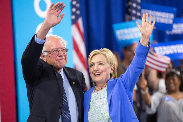 Presumptive Democratic presidential candidate Hillary Clinton and Bernie Sanders wave after speaking at a rally in Portsmouth, New Hampshire where she received Sanders' endorsement on July 12.