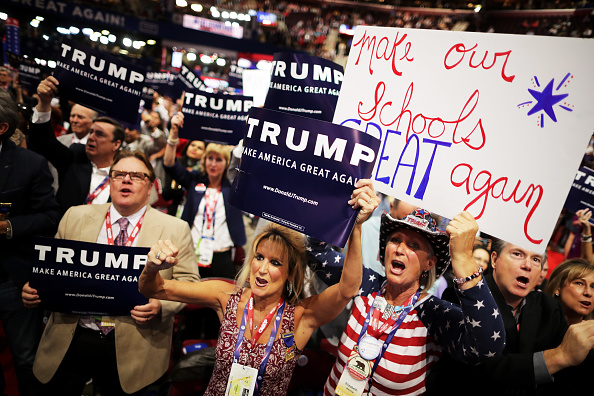Delegates hold signs in support of Republican presidential candidate Donald Trump, on the second day of the Republican National Convention on July 19 in Cleveland, Ohio.