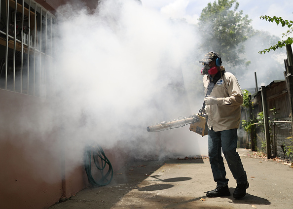 Carlos Varas, a Miami-Dade County mosquito control inspector, uses a Golden Eagle blower to spray pesticide to kill mosquitos in the Wynwood neighborhood as the county fights to control the Zika virus outbreak on August 2 in Miami, Florida.