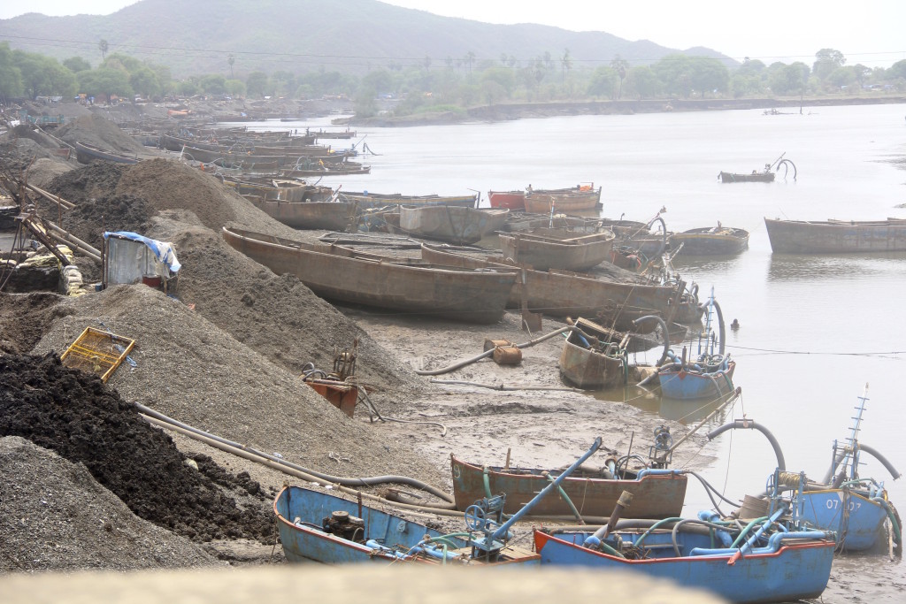 Sand miners' boats and suction pumps in India.