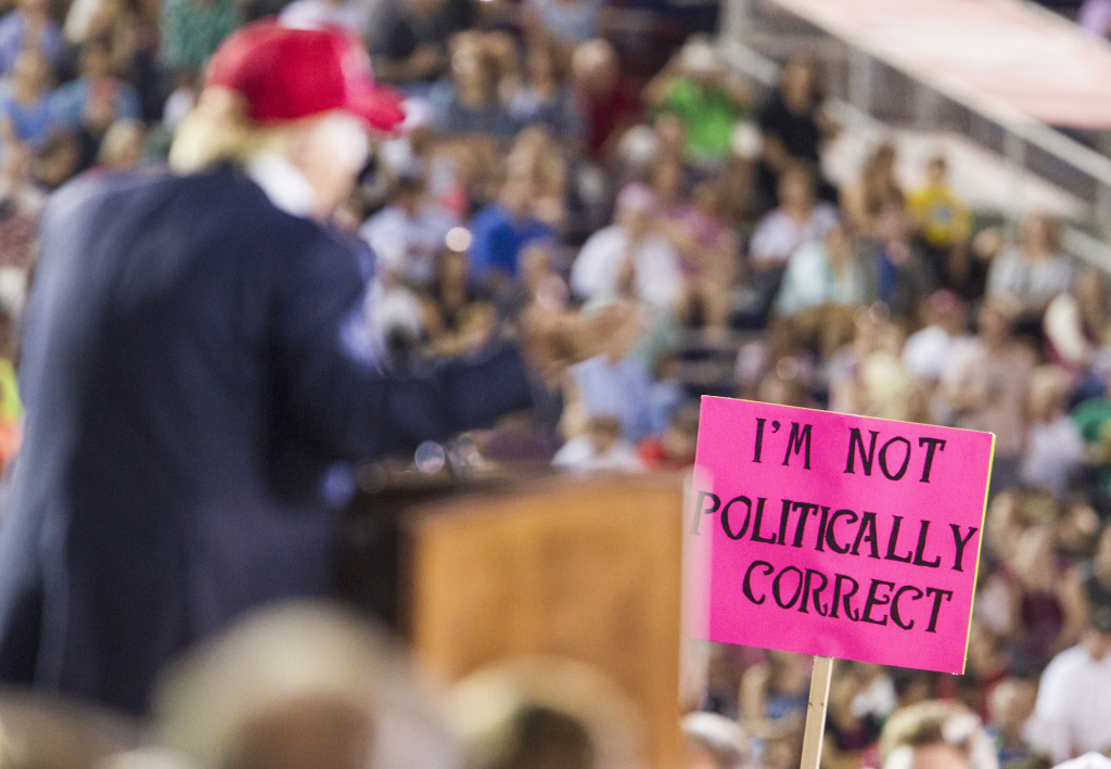 A supporter holds up a sign as Republican presidential candidate Donald Trump speaks during a rally at Ladd-Peebles Stadium on August 21, 2015 in Mobile, Alabama.