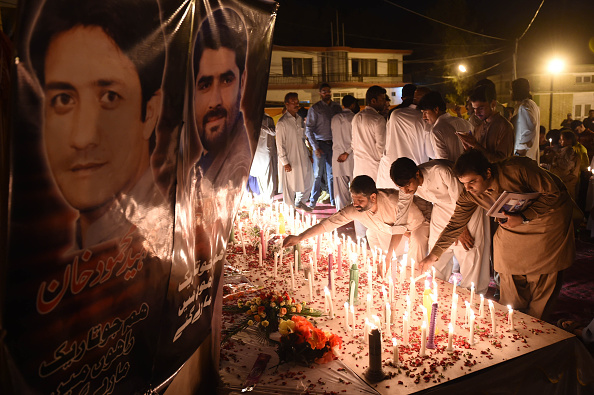 Pakistani journalists and civil society activists place candles during a vigil to pay tribute to victims of an August 8 suicide bombing at the Civil Hospital in Quetta on August 10.