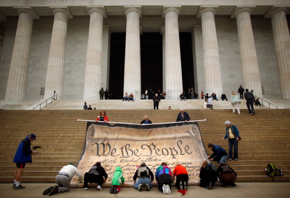 Volunteers roll up a banner printed with the Preamble to the United States Constitution during a demonstration against the Supreme Court's Citizens United ruling at Washington, DC's Lincoln Memorial in October 2010.