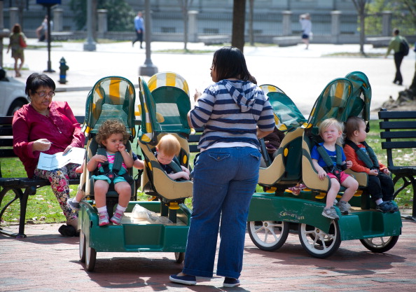 A daycare employee watches children in carts at a park in downtown Washington, DC on April 11, 2013.