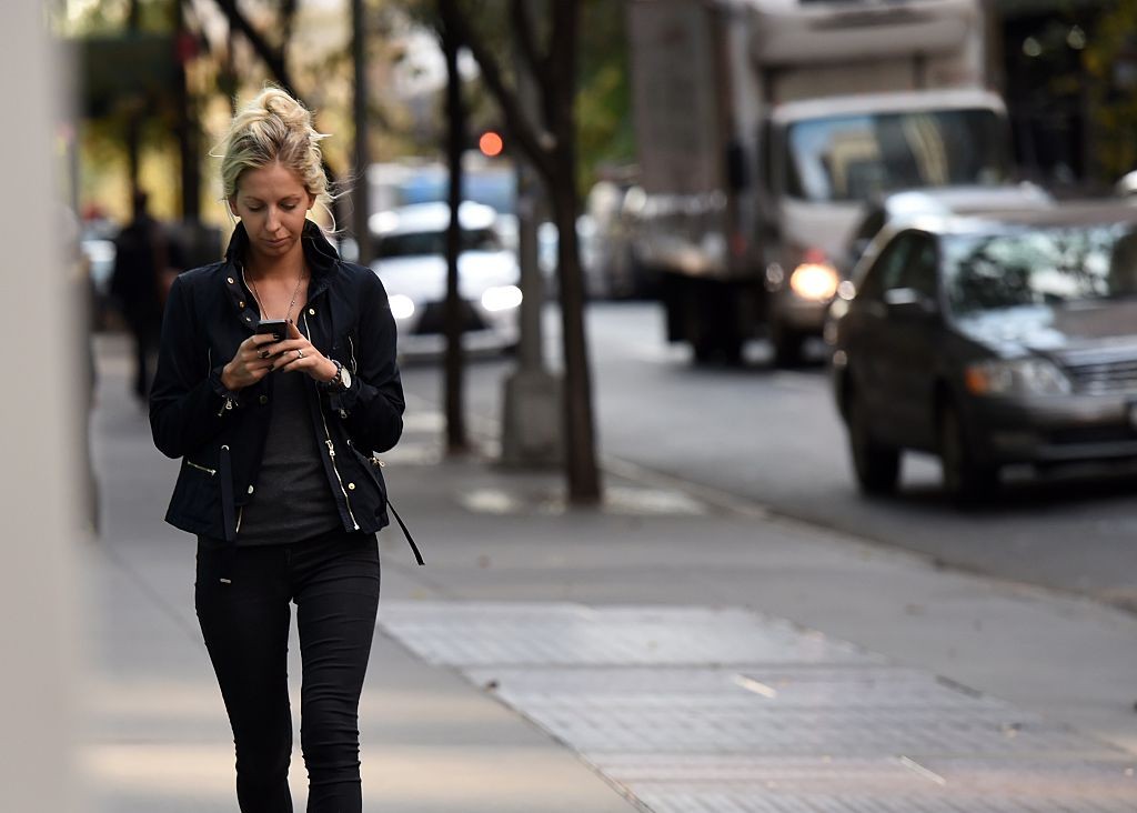 A woman uses her smart phone as she walks on 47th Street November 13, 2014 in New York.   AFP PHOTO/Don Emmert        (Photo credit should read DON EMMERT/AFP/Getty Images)