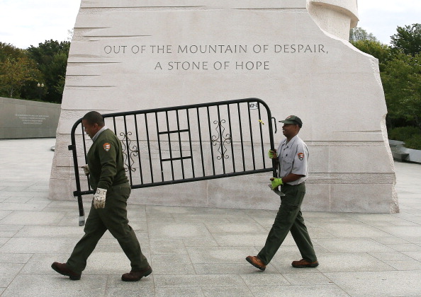 After a bill was passed by the House and the Senate to reopen the government in 2013, U.S. Park Service workers carry a barricade that had been used to close the Martin Luther King Memorial.  